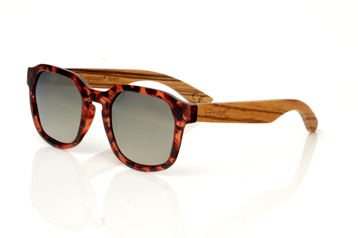 Wood eyewear of Zebrano modelo MOON CAREY. MOON CAREY are everything you need to give an interesting twist to your routine. With their tortoiseshell frames in matte brown and black tones and hexagonal shape, these glasses capture the essence of everyday style. The special part comes with the Zebrano wood shafts, whose unique grain ensures that no two pairs are the same. Comfortable, with total protection and perfect for any adventure under the sun. They are a basic with an extra touch. Give your look that something special. Front measurement: 148x50mm. Caliber: 53. | Root Sunglasses® 